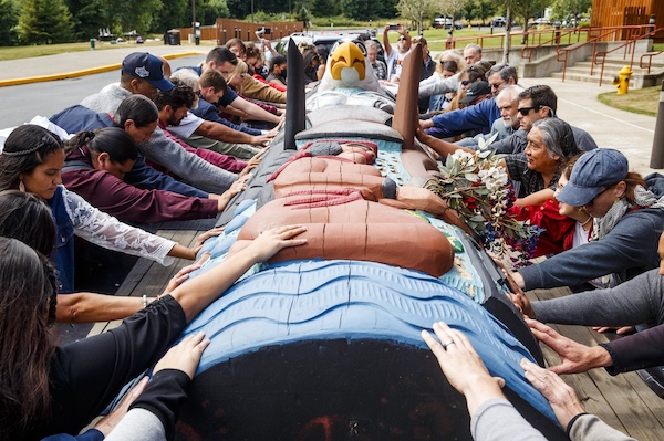 Tribal members and attendees of the Salmon Orca Summit bless a totem pole's cross-country journey and the summit's mission at the Little Creek Casino in Shelton on July 7, 2021. (Amanda Snyder / The Seattle Times)