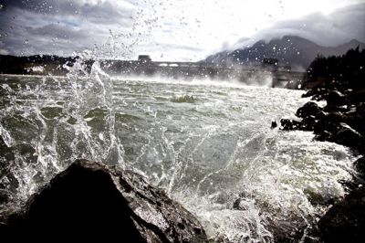 (Jamie Francis) Water from The Columbia River splashes high as it meets rocks on shore just below Bonneville Dam.