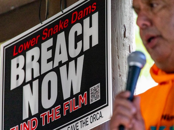 Julian Matthews speaks at the All Our Relations: Snake River Dam Campaign in front of a sign for the film 'Breach Now' Sept. 30, 2023 at Hells Gate State Park in Lewiston, Idaho. (Cole Quinn photo)
