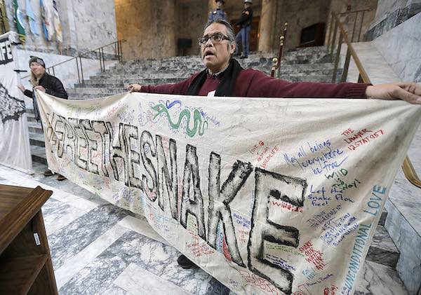 Elliott Moffett, a member of the Nez Perce Indian tribe, holds a sign that reads 