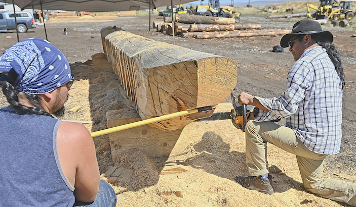 INez Perce tribal members Allen Pinkerton Jr., right, and Adam Capetillo, work to perfect the bow angle on a dugout canoe Saturday, Aug. 8. The canoe is being made from logs donated by JZ Lumber Co., of Joseph. The two started work on the craft at JZ Lumber’s property in Joseph.