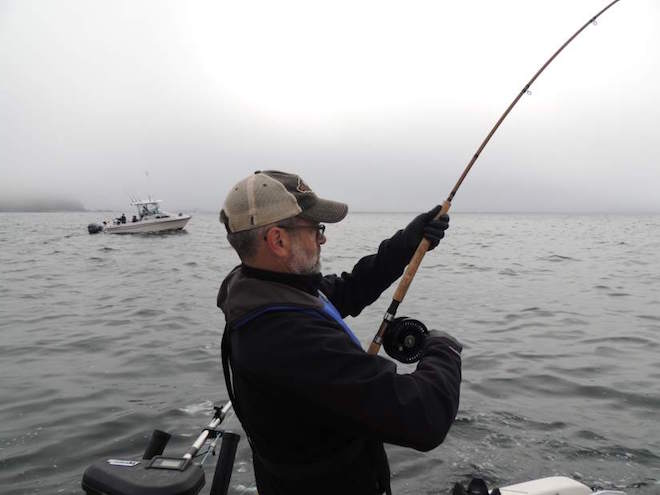 Bill Valentine, of Bend, fights a salmon off the coast of Vancouver Island near Kyuquot, British Columbia. (Gary Lewis/The Columbian)