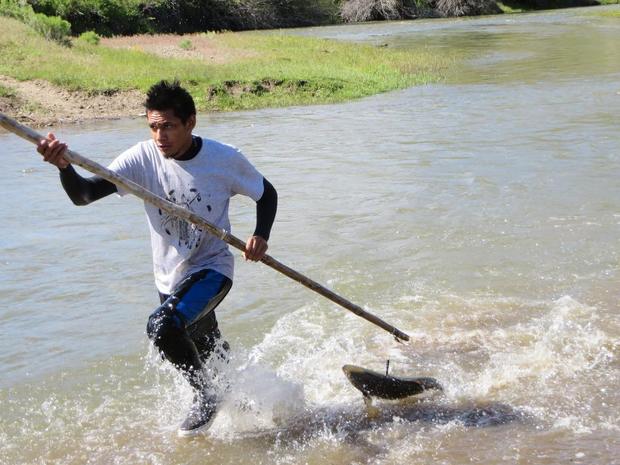 Ethan Thomas, a Shoshone Paiute fishermen, races to shore with a freshly caught chinook salmon from the Owyhee River on the Idaho Nevada border. Tribal leaders held a spearing workshop the night before the fish were released to help tribal members learn the traditional methods of fishing salmon. (SHOSHONE PAIUTE FISHERIES photo)