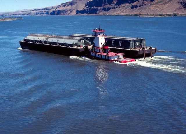 Tug pushes a wheat barge on a Lower Snake River reservoir.
