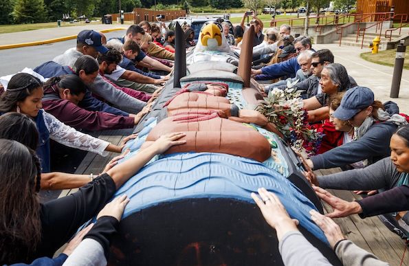 Tribal members and attendees of the Salmon Orca Summit bless the totem pole’s cross-country journey, called the Red Road to D.C., and the summit’s mission. The totem pole journey will continue to raise awareness in calling for protecting sacred lands and waters of Indigenous people, including protecting salmon and orcas. (Amanda Snyder photo)