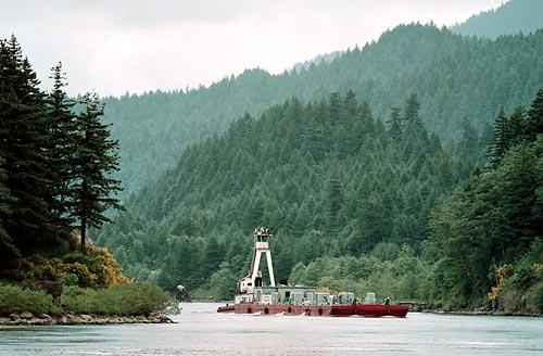 A juvenile-fish transport barge rounds a bend in the Columbia River near Bonneville Dam in this June 1999 photo. A federal judge yesterday ordered more water spilled this summer at four federal dams along the Snake and Columbia rivers in an effort to boost an endangered run of chinook salmon.