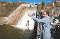 (Colin Mulvany) Worker Jerry LaQue hauls a rainbow trout from the canal at Russell D. Smith Power Plant Monday after water released into a maze of ditches supplying southern Columbia Basin irrigators.