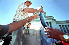 (Paul Joseph Brown) Protesting Cathlamet fishermen Steve Farnsworth and Marty Kuller placed free silvers in the hands of anyone who wanted one at the state Capitol yesterday.