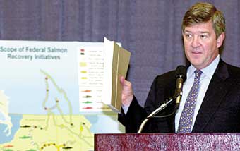 George Frampton, acting chairman of the White House Council on Environmental Quality, holds up the biological study for the All-H federal salmon recovery strategy plan released Thursday in Portland