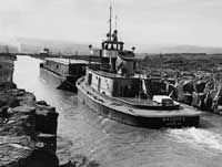  (OREGON STATE ARCHIVES, OREGON DEPARTMENT OF TRANSPORTATION, OHD5572) Grain barge in the Celilo Canal at The Dalles, 1953.