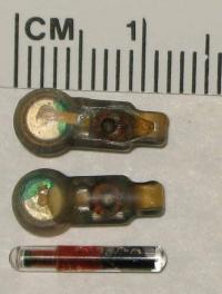 Two tags from the Juvenile Salmon Acoustic Telemetry System sit above a tag from the widely used Passive Integrated Transponder fish tracking system.