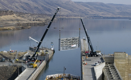 (Brent Wojahn) Cranes lift replacement gate into position at John Day Dam's navigation lock.