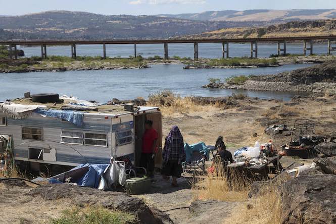 This Aug. 22, 2014, file photo shows the home of Ranetta Spino and her family at the river's edge at Lone Pine, a Native American fishing site on the Columbia River near The Dalles, Ore. Federal legislation to assess 31 tribal fishing sites in Oregon and Washington and make critical improvements to sewer and water systems has passed the U.S. House after three years of delays. (AP Photo/Gosia Wozniacka, File)