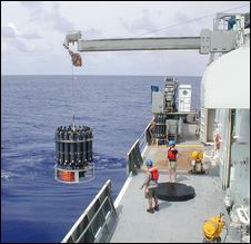(Christopher Sabine, NOAA) Scientists lower 36 bottles used for water sampling from the deck of the Thomas G. Thompson while doing research near the equator.