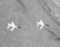 Two NASA F/A-18 aircraft fly in an autonomous formation, where the second plane surfs the swirling tunnel of air from the first plane, in this Sept. 20 NASA photo over the Mojave Desert, Calif.