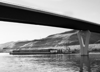 A barge travels under the Red Wolf Crossing bridge at Clarkston, Wash., bound for the Port of Portland. The Columbia River transportation network allows inland producers to expand markets, particularly in Asia.