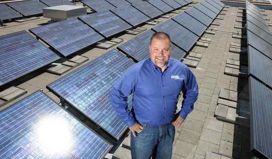 In this July 29, 2011, file photo, Mark Stokes, manager of Idaho Power's power supply planning, poses for a photo on the roof of the agency's downtown Boise, Idaho building where a solar array has been gathering energy.
