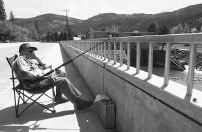 Vic Bruderer, of Spokane, fishes for Salmon off a bridge in Orofino on Friday. 